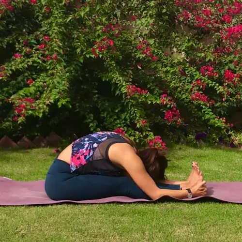 a woman performing paschimottanasana